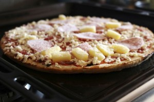 Frozen pizza with ham and pineapple on the plate