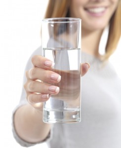 Happy woman hand holding a fresh glass of water