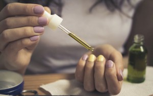 Women's hands take care of cuticles with oil
