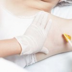 Professional woman at spa doing epilation armpits using sugar - sugaring