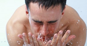 Young man washing face.