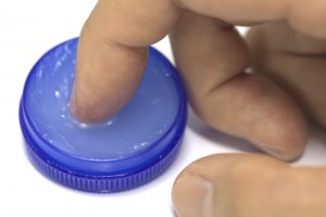 Closeup of male hand using finger rubbing white gel
