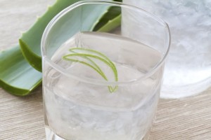 Glass with aloe drink and leaf as closeup
