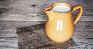 clay milk jug isolated on wooden background