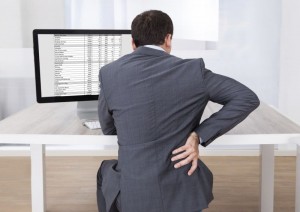 Businessman Suffering From Backache While Sitting At Desk